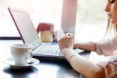 Kafedeki bir masada dizüstü bilgisayarda çalışan güzel bir kız.