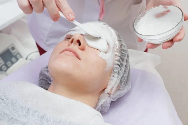 Un cosmetólogo realiza una limpieza ultrasónica de la piel de la cara . — Foto de Stock