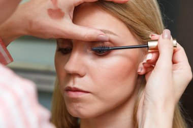 Makyöz, modelin şehvetli kirpiklerini oluşturuyor..