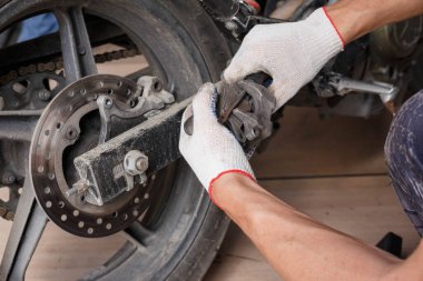 Bir motosiklet üzerinde fren balataları değiştirme işlemi.