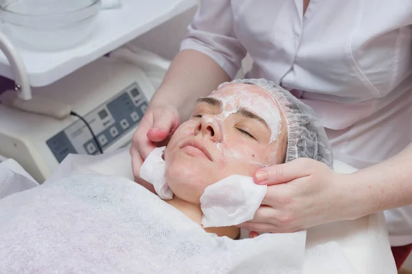 Kosmetyczka myje twarz kobiety za pomocą poduszki bawełniane. Przygotowanie do czyszczenia twarzy — Zdjęcie stockowe