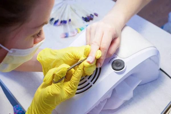 Wykwalifikowany specjalista w zakresie pielęgnacji paznokci w gumowych rękawicach ochronnych — Zdjęcie stockowe