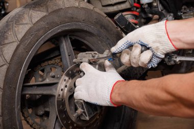 Bir motosiklet üzerinde fren balataları değiştirme işlemi.