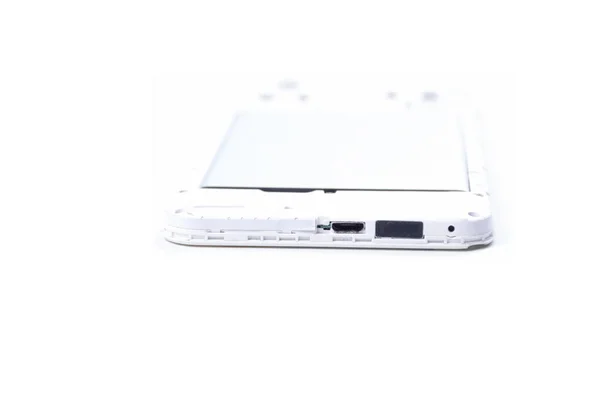 Un teléfono celular con una cubierta abierta yace boca abajo sobre un fondo blanco . — Foto de Stock