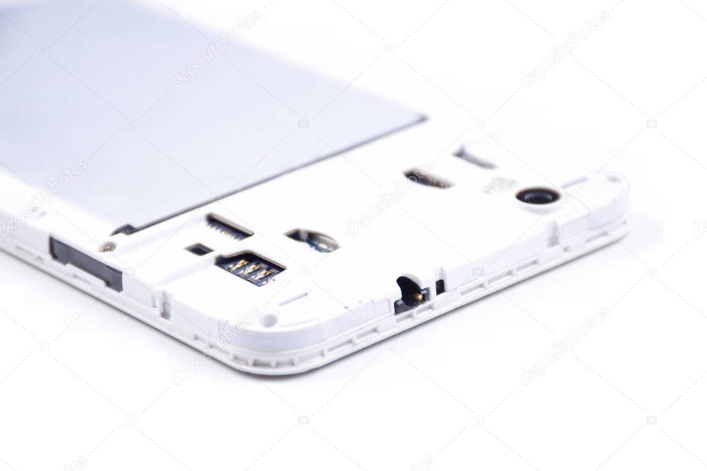 A cell phone with an open cover lies face down on a white background.