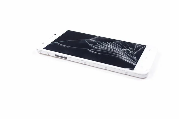 Telefone branco com uma tela quebrada em um fundo branco . — Fotografia de Stock