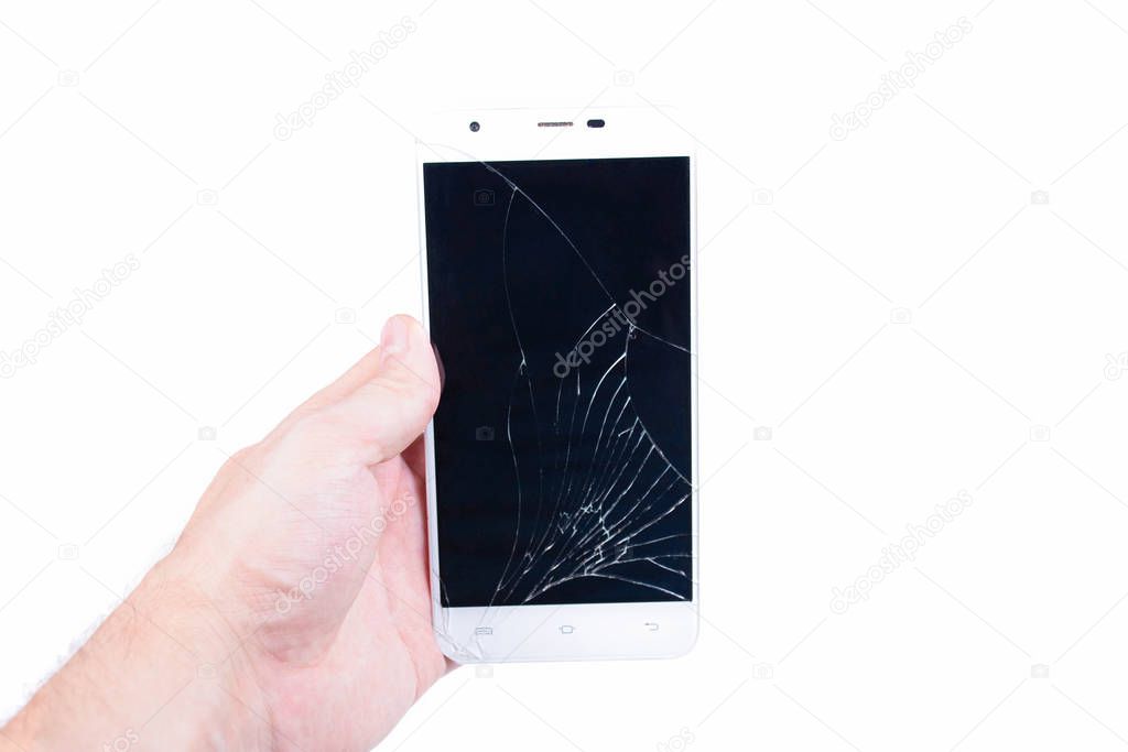 Mans hand holds a phone with a broken screen.