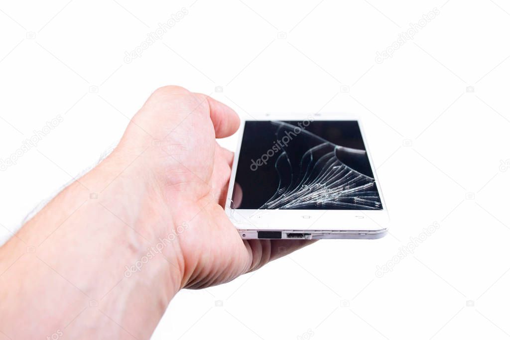 Mans hand holds a phone with a broken screen.