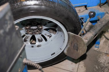 Üstat arabaların lastiklerini çıkarıyor.