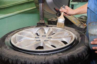 Üstat arabaların lastiklerini çıkarıyor.