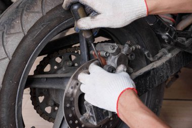 Bir motosiklet üzerinde fren balataları değiştirme işlemi.