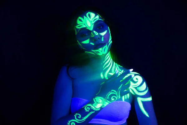 Ultraviyole ışıldayan bir kızın vücudunda ve elinde vücut sanatı — Stok fotoğraf