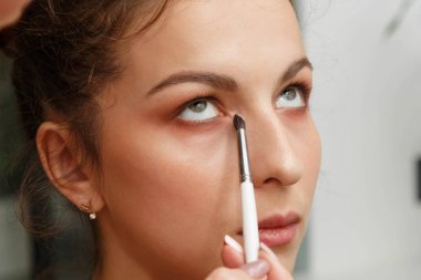 Makyaj yapma süreci. Makyaj sanatçısı bir bru ile çalışıyor