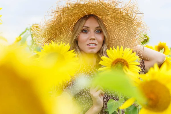 Porträt eines hübschen Mädchens in einem Sonnenblumenfeld. — Stockfoto