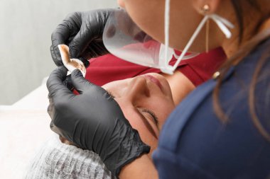 Usta, ameliyattan sonra fazla kaş makyajı boyasını kaldırır. Kalıcı Kaş Makyajı Prosedürü.