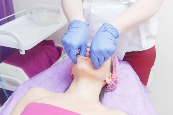 The master carries out a beech massage procedure. Buccal massage procedure provided to the client. cosmetologist makes a buccal massage of the patient\'s facial muscles.