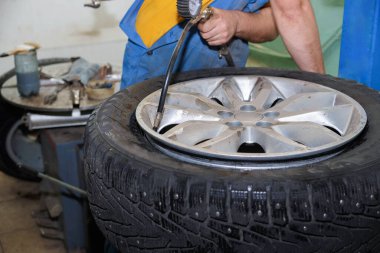 Usta araba için monte edilmiş tekerleği şişirir. Mevsimden önce lastikleri değiştirmek..