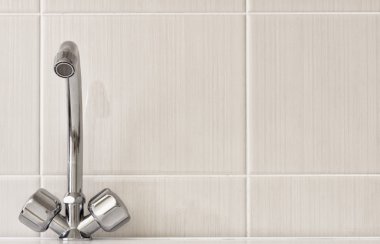 Su musluklar, kiremitli bir duvar arka planı.