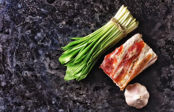 A piece of meat and garlic with wild garlic. — Stock Photo, Image