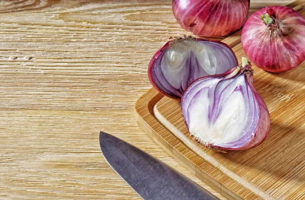 Tubers of red onions, on a wooden background — Stock Photo, Image