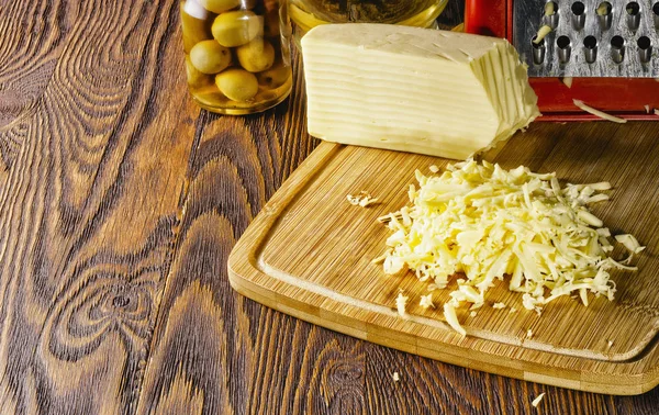 Tiras ralladas de queso fresco sobre la mesa —  Fotos de Stock