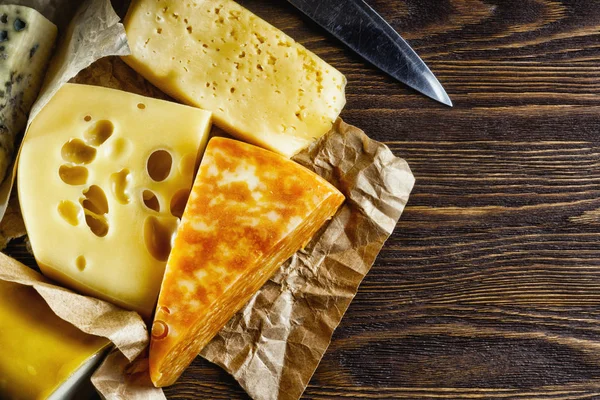 Pedazo de queso fresco aromático acostado sobre la mesa —  Fotos de Stock