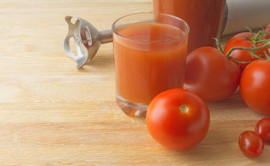 Domates smoothies ve ahşap arka plan üzerinde blender