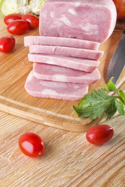 Piece of delicious ham and tomatoes on wooden background — Stock Photo, Image