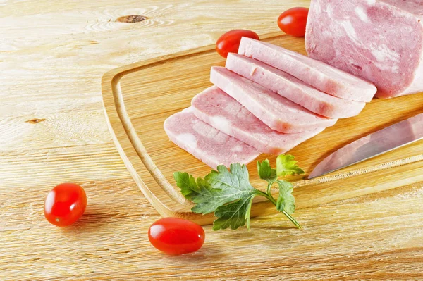 Piece of delicious ham and tomatoes lying on the table — Stock Photo, Image