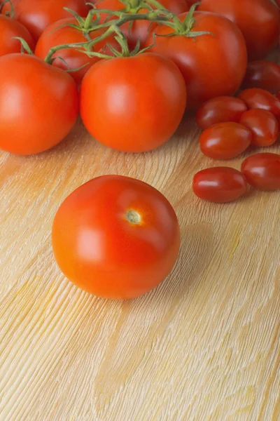 Rijpe tomaten, liggend op een houten tafel — Stockfoto