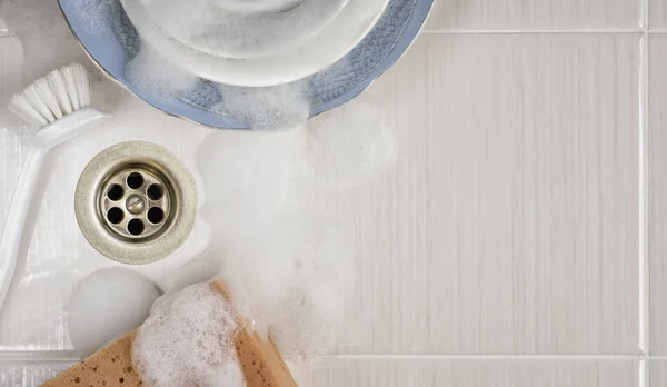 Dishes in the sink with a brush and sponge — Stock Photo, Image