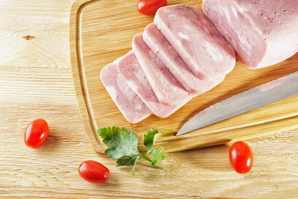 Piece of delicious ham and tomatoes lying on a wooden table — Stock Photo, Image
