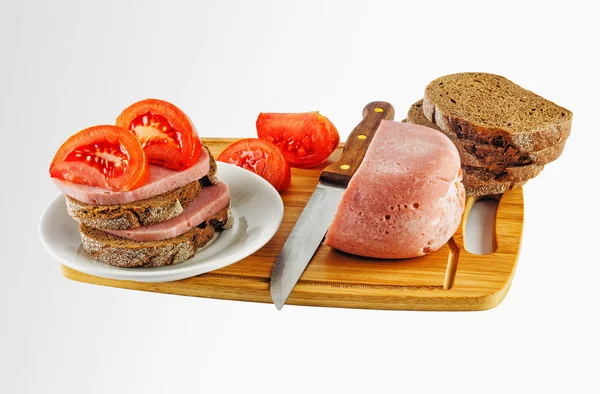 Ham and tomatoes on a cutting Board with a knife — Stock Photo, Image