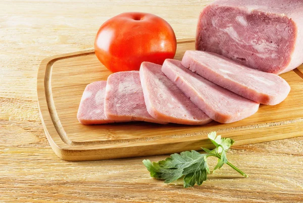 Cut a piece of ham and tomatoes lying on the table — Stock Photo, Image