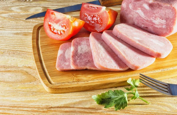 Ham and tomatoes on wooden background — Stock Photo, Image