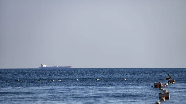 Obchodní loď na moři na vozovně a rybářská síť — Stock fotografie