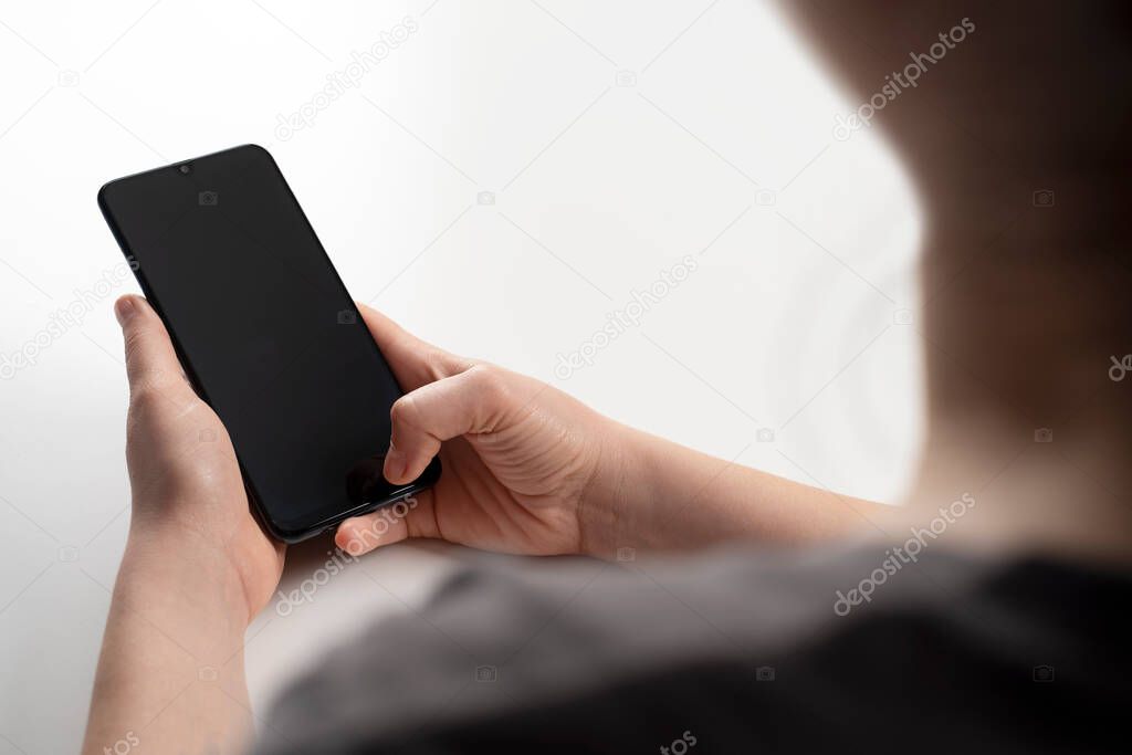 Young woman using apps on a mobile touchscreen smartphone. Concept for using technology, shopping online, mobile apps, texting, addiction, videocall, swipe. Work at home. 