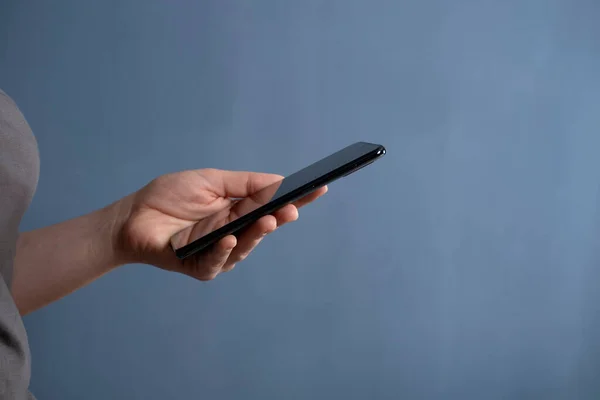 年轻女性在手机触摸屏智能手机上使用应用程序 使用技术的概念 网上购物 移动应用 发短信 在家工作 免版税图库照片