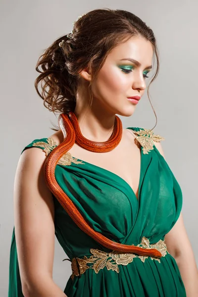 girl in a green dress with a snake woman and snake