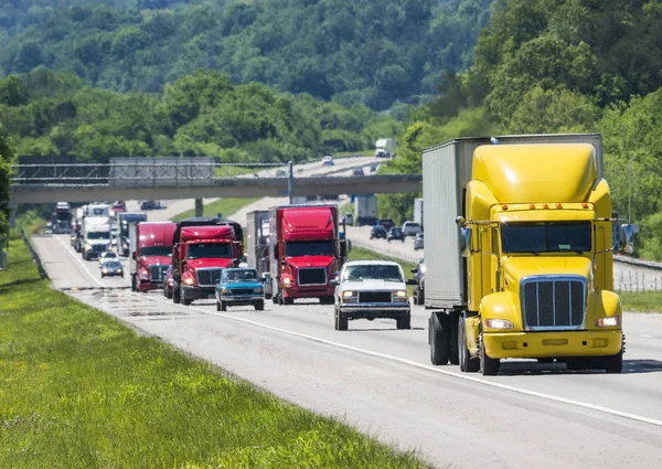 Un semirremolque amarillo conduce una línea llena de tráfico por una interestatal en el este de Tennessee — Foto de Stock