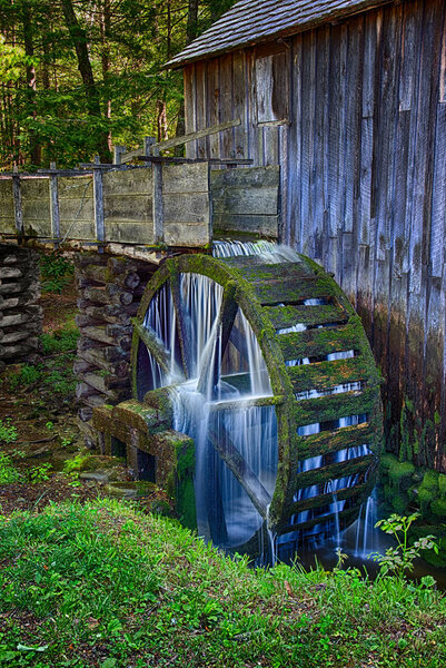 Вода все еще течет и все еще поворачивает колесо в столетии (плюс) старая мельница Cable Grist в Кейдс-Коув в Национальном парке Great Smoky Mountains

