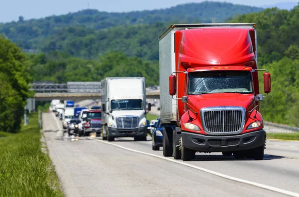 En röd semi leder kö ner en interstate highway i Tennessee — Stockfoto