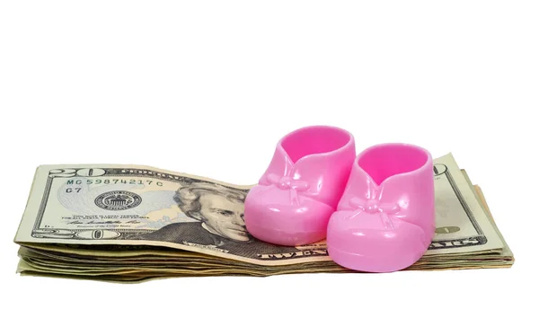 Girl Baby Booties Sitting on a Stack of  Money With Shadows Royalty Free Stock Photos