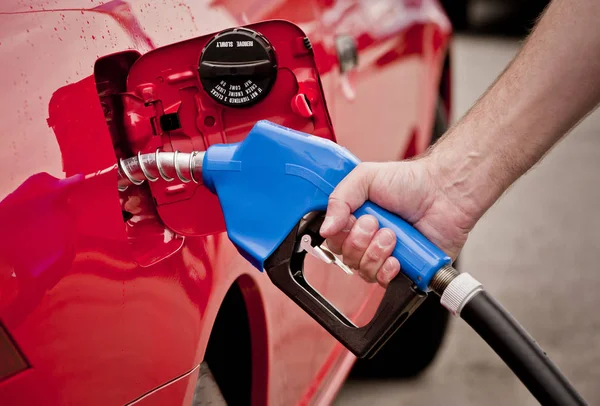 Mans Hand Pumping Gasoline Into the Fuel Tank of a Red Car — Stock Photo, Image