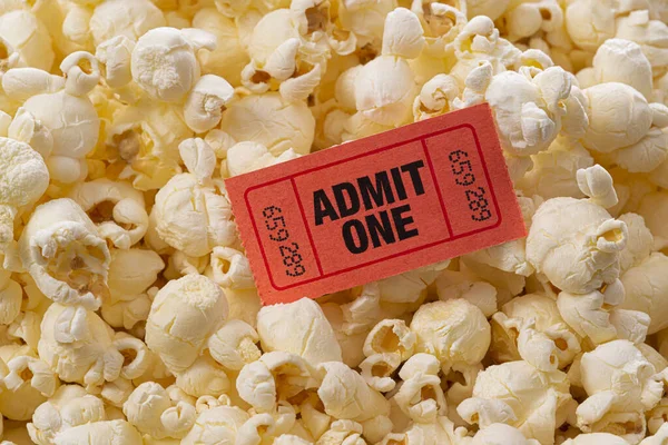 Horizontal close-up shot of popcorn with a movie ticket on top.