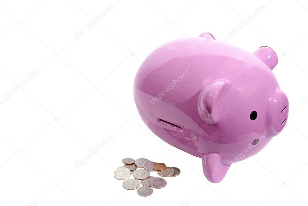 Horizontal shot of a pink piggy bank lying on its side with the slot on top facing toward the camera.  Pile of coins next to it.  White background.  Copy space.