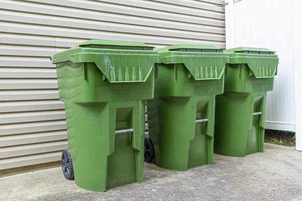 Horizontale Opname Van Drie Groene Plastic Vuilnisbakken Tegen Buitenmuur Van — Stockfoto