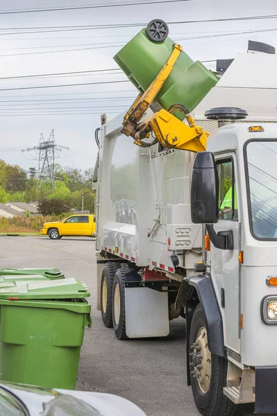 Pionowe Ujęcie Śmieciarki Robotem Wyrzucającym Śmieci Zielonego Plastikowego Śmietnika — Zdjęcie stockowe