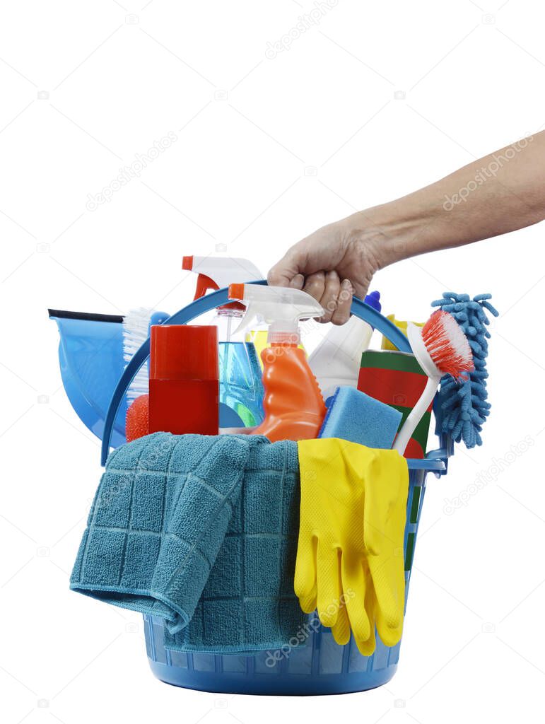 Vertical shot of a female hand holding a round blue plastic basket of cleaning supplies. White background. 