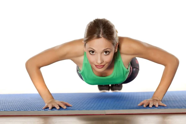 Junge schöne Frau macht Liegestütze — Stockfoto